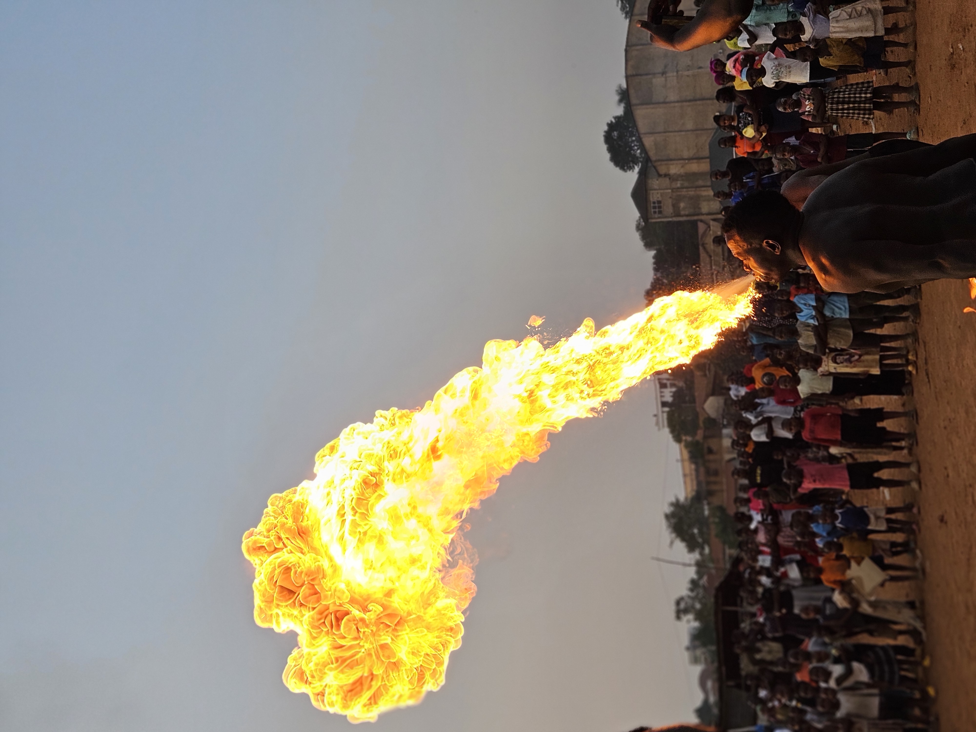 Kiguli Lawrence performing fire breathing during an evening Acromind event